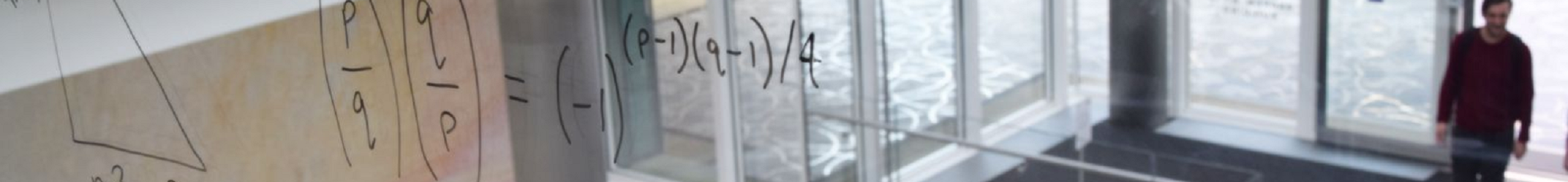 Maths (the law of quadratic reciprocity) written on a window in the Mathematical Institute, with the Penrose tiles in the background.