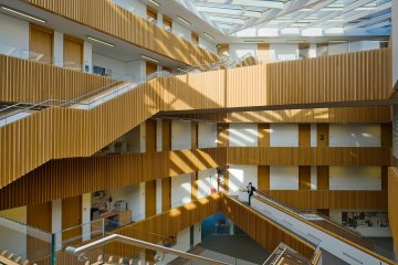 The inside of the Andrew Wiles building; white walls and pale wooden staircases, flooded with sunlight