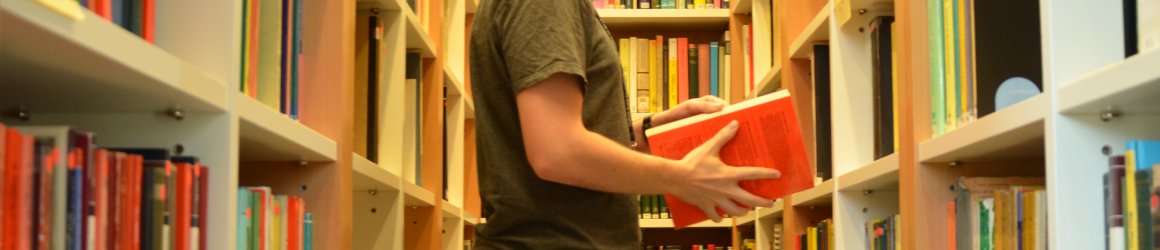 A student with a book in a library