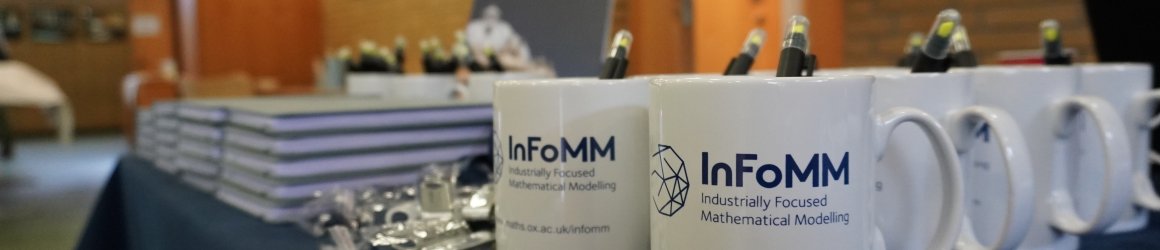 table full of InFoMM CDT mugs and conference paraphernalia