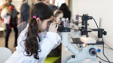 Photo of young chilldren looking down microscopes