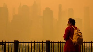 A woman wears an N95 face mask to protect against lung damage from wildfire smoke