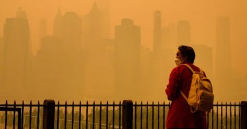 A woman wears an N95 face mask to protect against lung damage from wildfire smoke