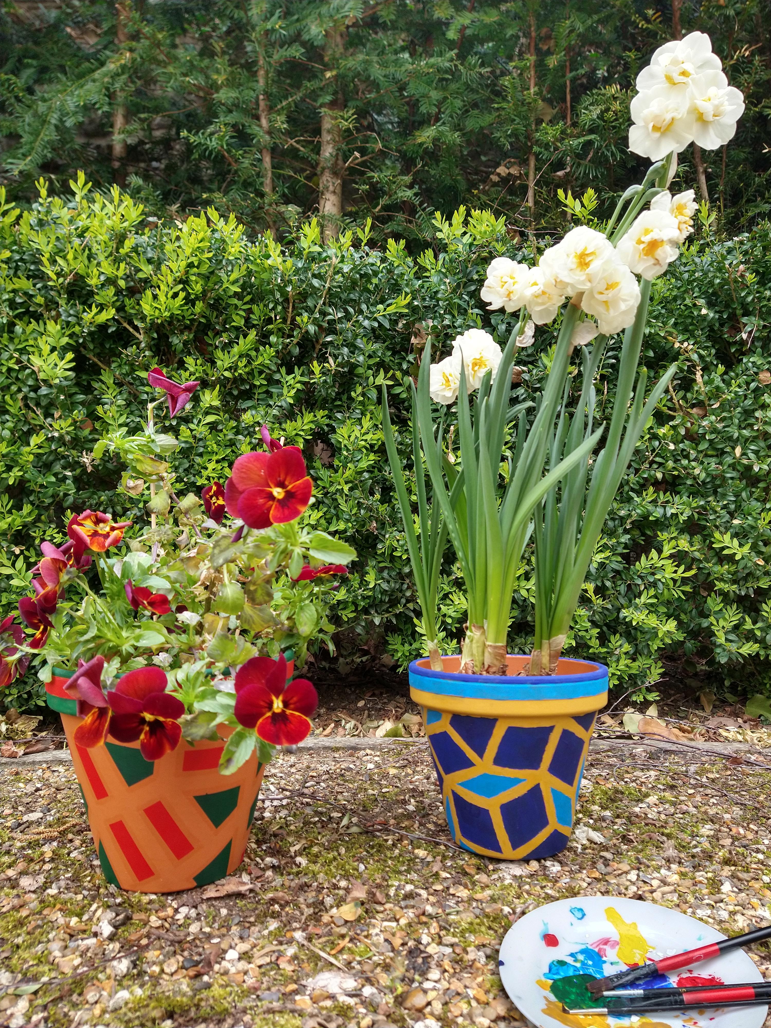 Flower pots painted in bright colours with aperiodic tiling patterns.