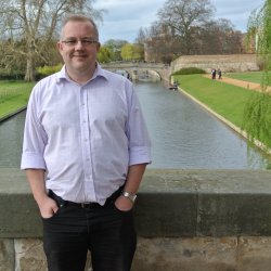 Richard Earl stood on a bridge by the backs in Cambridge