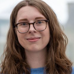 A headshot of Katherine smiling in a blue jumper.