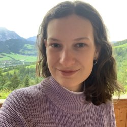 Picture of Alexandra Holzinger with green mountains in the background Picture of Alexandra Holzinger with green mountains in the background