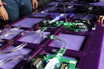 A system of batteries and wires/pipes, laid out like a circuit board, all purple & blue in colour A system of batteries and wires/pipes, laid out like a circuit board, all purple & blue in colour