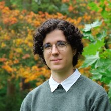 Portrait of Alba with trees in the background.