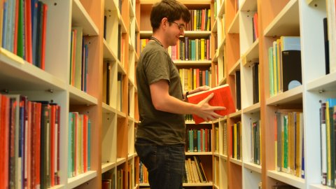 A student with a book in a library