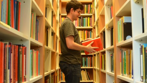 A student with a book in a library