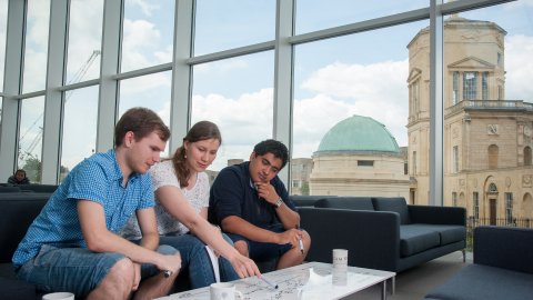 Three MSc students working together in the common room.