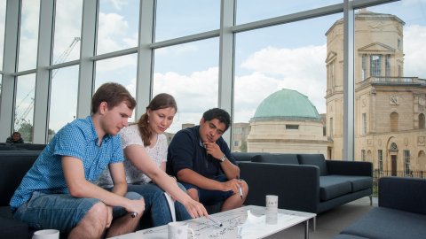 Three MSc students working together in the common room.
