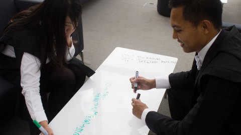 Students working on a whiteboard coffee table