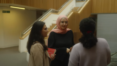Three women talking near a staircase Three women talking near a staircase