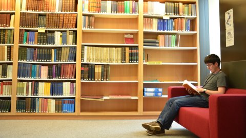 A student reading in the Whitehead Library at the Mathematical Institute.