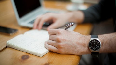 close up of a table top with notebook and laptop