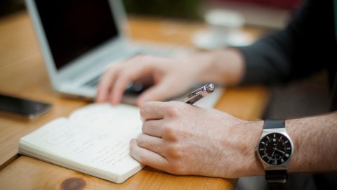 close up of a table top with notebook and laptop